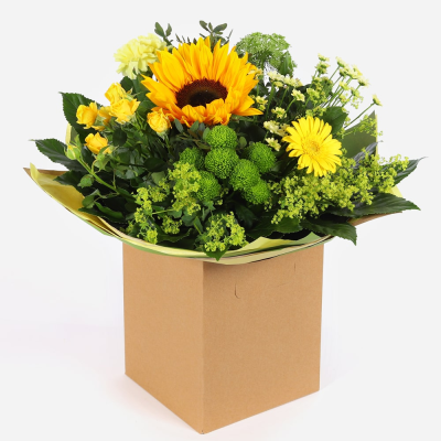 Golden Glow - Brighten someone’s day with the "Golden Glow" arrangement, featuring a stunning sunflower mix with seasonal blooms. Complemented by lush green foliage, this arrangement brings a touch of nature’s radiant beauty into any space.
